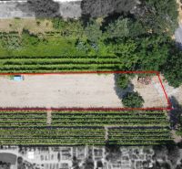 A plot for residential use in Pezinok on Holubyho Street surrounded by greenery and a road.