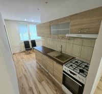 A kitchen with a wood-patterned floor in a 3-room apartment, bright room, appliances.