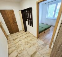 The entrance hall of a 3-room apartment with coat racks and a view into the bedroom.