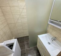 Bathroom in a 3-room apartment with a washing machine, sink, and beige tiles.