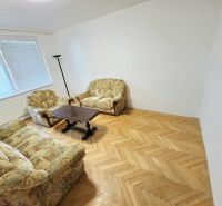 Living room in a 3-room apartment with comfortable seating and a wooden decor floor.