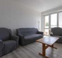 Living room in a 3-room apartment with armchairs, a sofa, and a wooden-decor floor.
