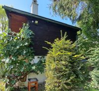 A cottage on Do Žlebín Street in Ružomberok surrounded by greenery and trees.