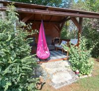 A cottage in Do Žlebín in Ružomberok with comfortable armchairs in a garden surrounded by greenery.