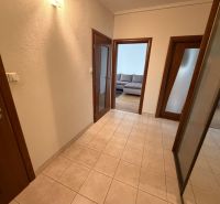 A hallway with tiles leading to the living room in a 3-room apartment.