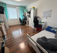 Children's room in a 3-room apartment with a wooden decor floor, a desk, and a bed.