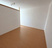 A room with white walls and a wooden decor floor in a 2-room apartment.