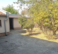 The courtyard of a family house in Nové Zámky with bushes and shrubs near the house.