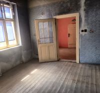 A room with wooden floor decor, blue walls, a bright window, open door.