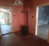 The interior of a family house with a tiled stove and spacious doors between rooms.