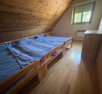Attic room with two beds and a wooden floor decor in the cabin.