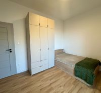 A room in a 4-room apartment with a bed, a wardrobe, and a floor with a wooden decor.