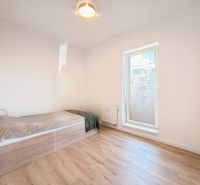 A bedroom in a 4-room apartment with a bed and a wooden decor floor.