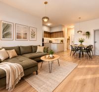Living room in a 4-room apartment with a sofa and decorations, wooden decor flooring.
