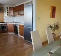 A kitchen with a wood-patterned floor in a 3-room apartment, modern furniture and decorations.