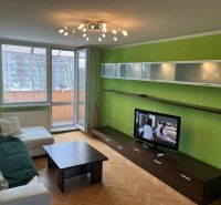A living room in a 3-room apartment with a wooden decor floor and green walls.