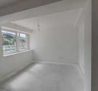 Interior of a 3-room apartment with white walls and a large window.
