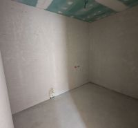 Bare walls and a concrete floor in a newly built 3-room apartment awaiting completion.