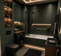 A luxurious bathroom with a bathtub and a washing machine in a 2-room apartment with plants.