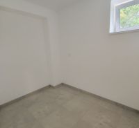 A room in a 3-room apartment with a light floor and a window, without furniture.
