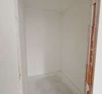 A small room without furniture in a 2-room apartment with bare walls.