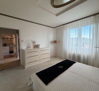 Master bedroom in a 4-room apartment with white furniture and a wardrobe in the background.