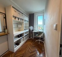 A wardrobe in a 4-room apartment with shelves, a table, and a wooden decor floor.