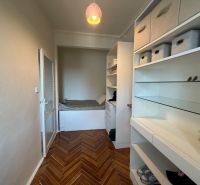 A wardrobe in a 4-room apartment with storage space and a floor with a wooden decor.
