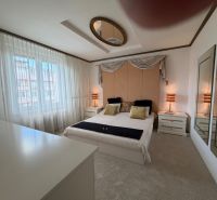 Bedroom in a 4-room apartment with a double bed, nightstands, and mirrors on the walls.