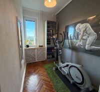 A stylish room in a 4-room apartment with exercise equipment and a decorative painting.