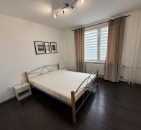 Bedroom in a 3-room apartment with a bed and a window with brown curtains.