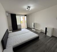 Bedroom in a 3-room apartment with wood-patterned flooring and a balcony.