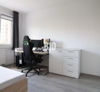 A room in a 3-room apartment with a spacious window, a desk, and a floor with a wooden decor.