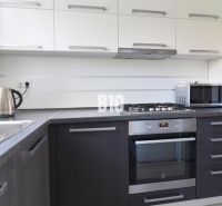 A modern kitchen in a 3-room apartment with dark cabinets and silver appliances.