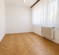 A room in a 3-room apartment with a wooden decor floor and a radiator.