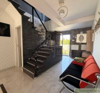 Interior of a family house with a sofa and staircase, floor with wooden decor.