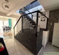A staircase in a family house with decorative stone and a view into the dining room.