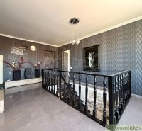 The interior of a family house with dark gray walls, decorative decorations, and a staircase.