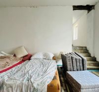 A bedroom in a family house with two beds and stairs.