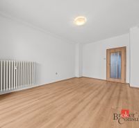 A room with a wooden floor decor and white walls in a 2-room apartment.
