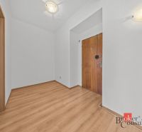 A hallway in a 2-room apartment with a wooden decor floor and light-colored walls.