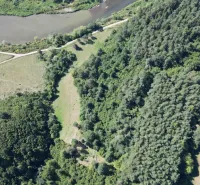 A river and roads surrounded by forests and fields in Plaveč on agricultural and forest land.