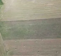 Aerial view of agricultural and forest lands in Plaveč with hay bales.