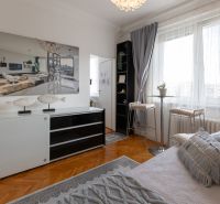 A bright room with wood-decor flooring, a sofa, and decorative elements in a 2-room apartment.