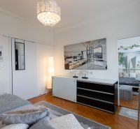 Bedroom with wood-patterned flooring, a bed, and modern lighting in a 2-room apartment.