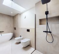 A bathroom with a bathtub, shower, and sanitary facilities in a 5 or more room apartment.