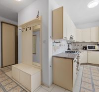 A kitchen in a 2-room apartment with white cabinets and built-in appliances.