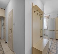 Entrance hallway in a 2-room apartment with white walls and modern furniture.
