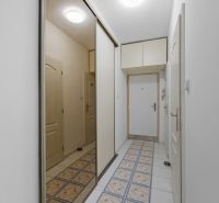 A hallway in a 2-room apartment with tiles and a built-in wardrobe.