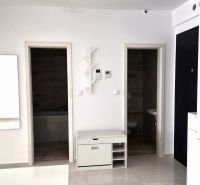 Interior of a 2-room apartment with white walls and doors to the bathroom and toilet.